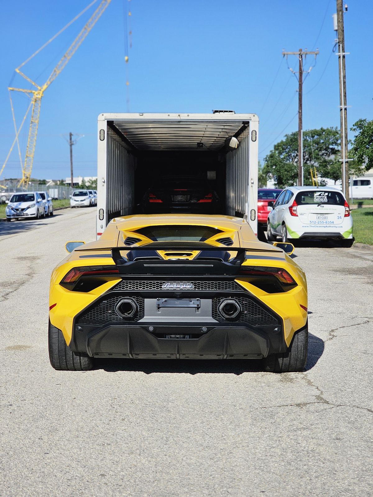 Yellow Lamborghini Huracan Tecnica loading into an enclosed trailer