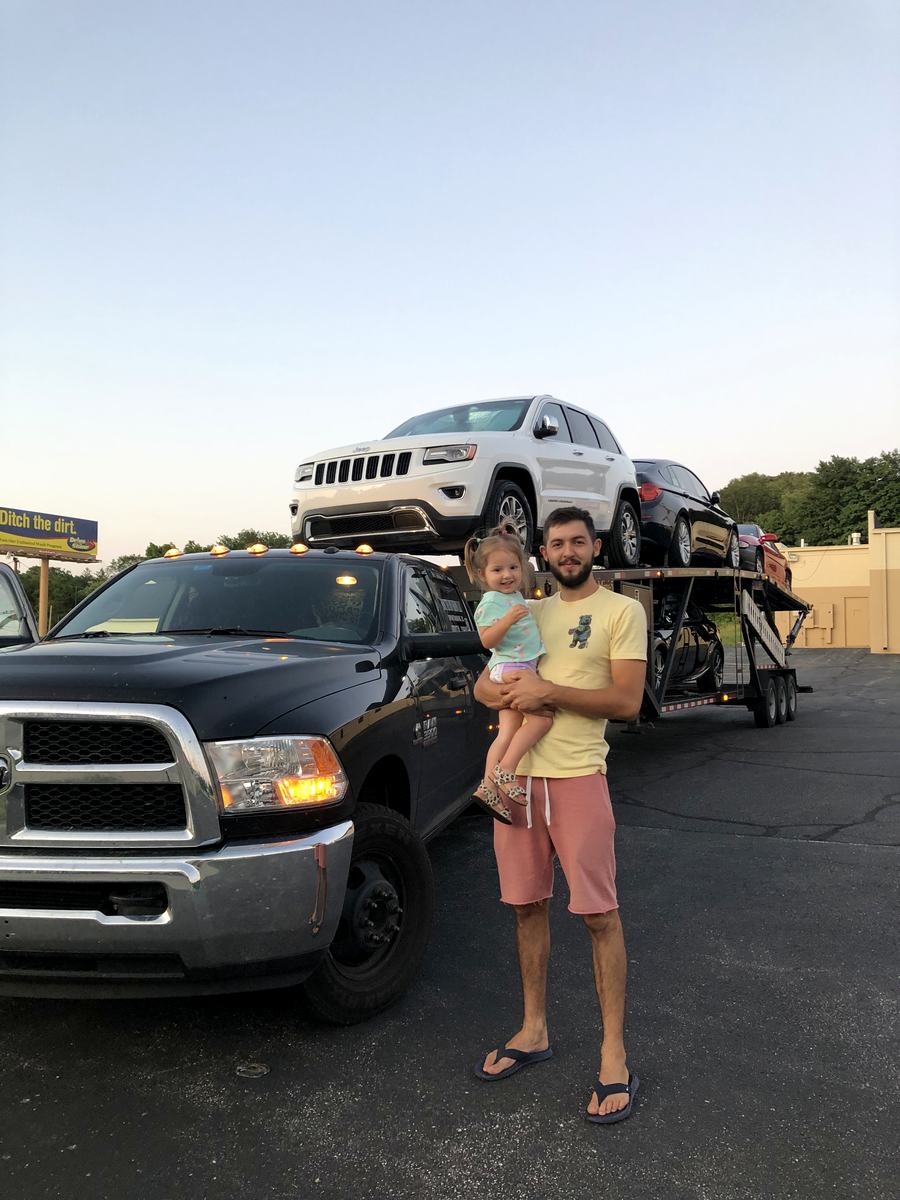 Founder of State Motors with his daughter in front of a loaded car hauler