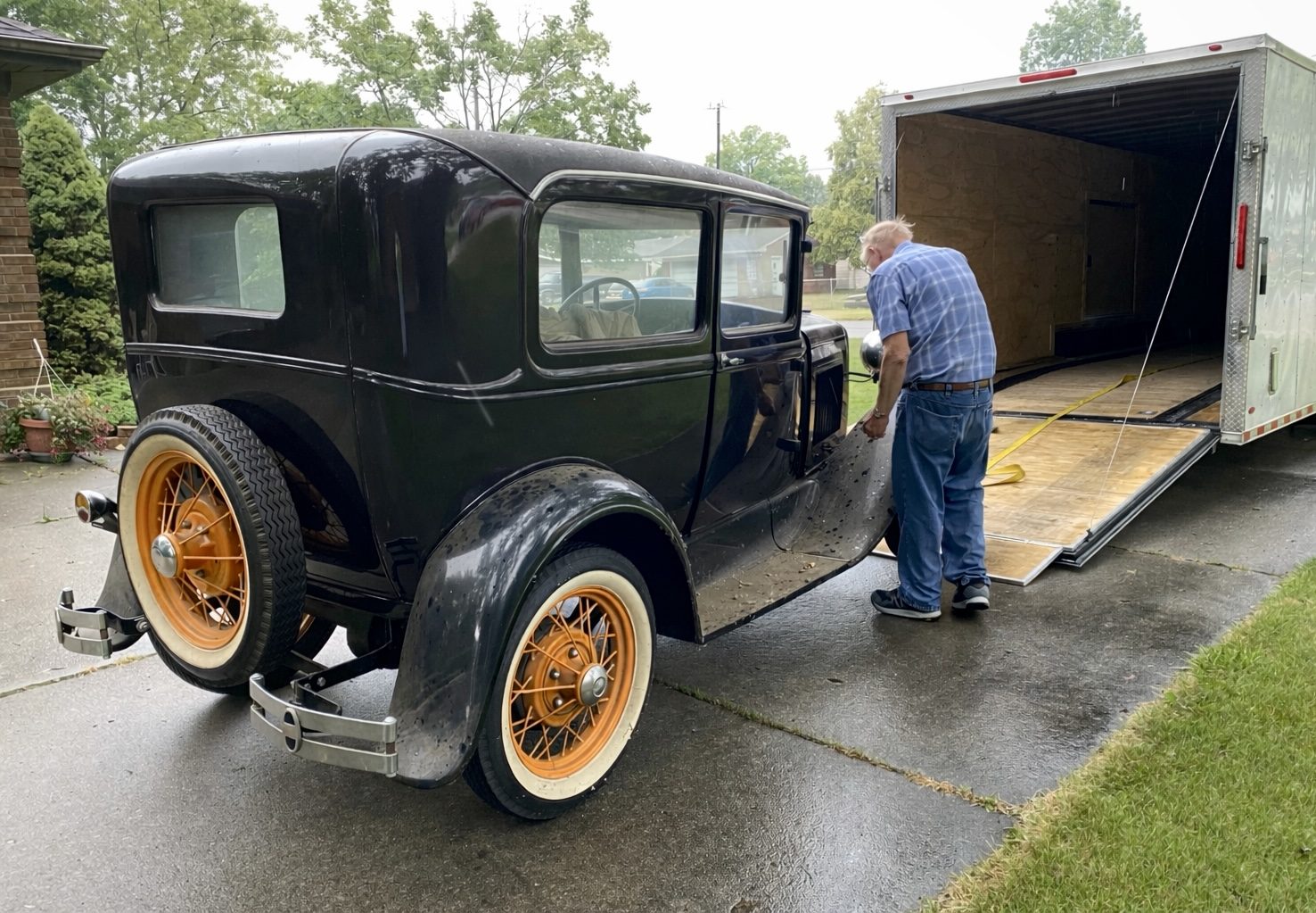 A century-old Ford Model A being loaded into an enclosed trailer